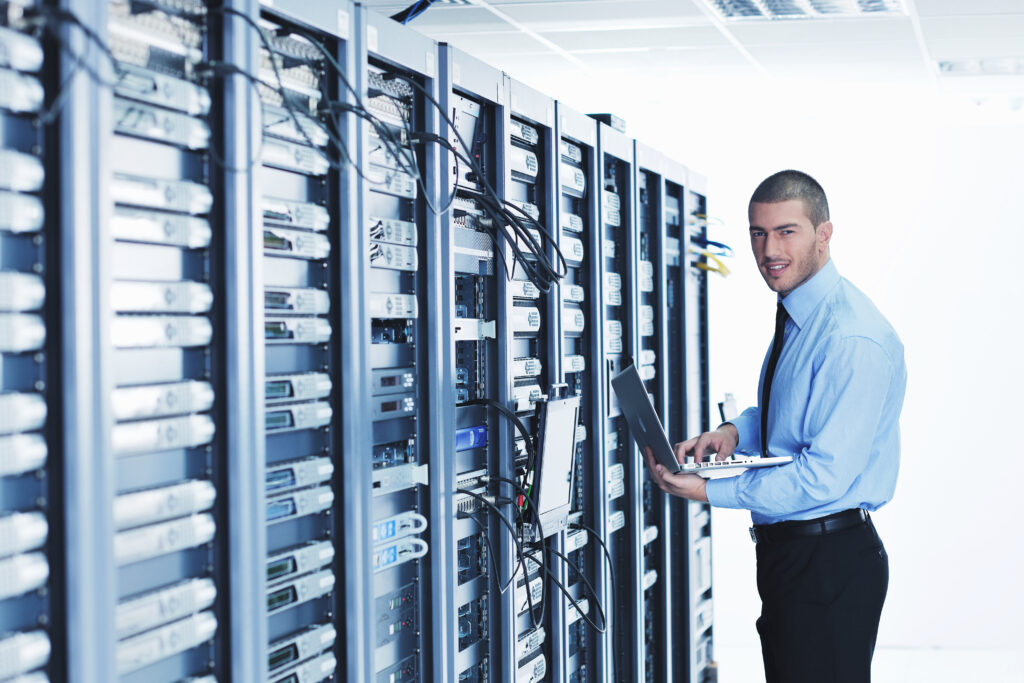 businessman with laptop in network server room